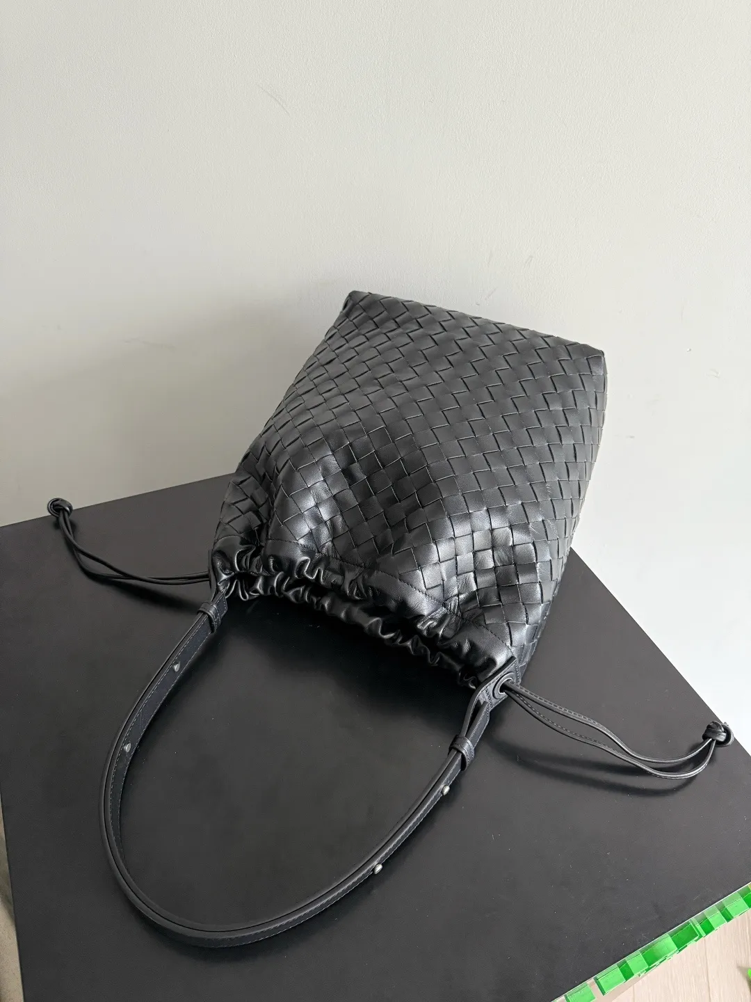 Batch 2280 BOTTEGA VENETA2025 new woven Biblioteca Bucket perfectly integrates casual texture, using classic Intrecciato woven leather, which feels soft but stiff, allowing the bag to drape naturally without losing the three-dimensional effect. The drawstring design of the drawstring pocket makes opening and closing more direct and adds a casual atmosphere. If you are on a short business trip, you can put some skin care samples in your bag. The front compartment or rear zipper can also be used to store ID cards, bank cards, etc. The solid color design of the bag is very versatile, and it doesn’t feel too picky when paired with any clothes. The leather material is also very high-quality! Style number: 836020 Size: 24*33*14cm